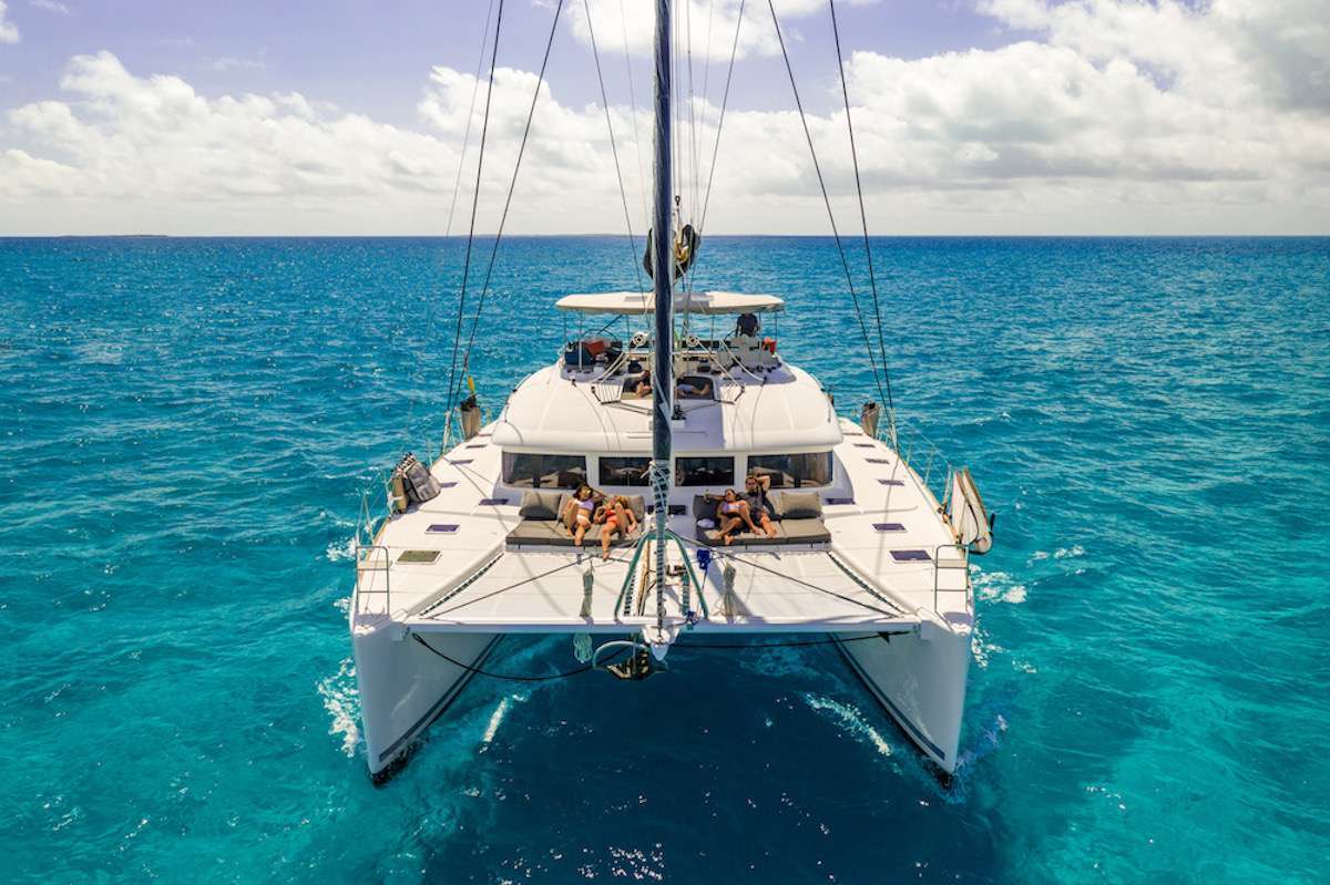 Huntress is a beautiful 2014 Lagoon 620 catamaran. The reputation of this yacht as the pinnacle of style and luxury is well earned. If you are looking to expand your horizons, and explore the world in new ways you have never imagined, then welcome to the experience of comfort and class that is Huntress. 

The design of the 620 has been perfected for socializing with seemingly endless space both above and below deck. This yacht shows why it is the gold standard as the setting for the perfect guest experience. With multiple dining, living, sunbathing, and lounge areas to choose from, you will always have the space to sneak away for some shade or to read a book.... or you can choose to get as involved as you desire. As a larger catamaran, you can count on greater comfort while at sea, and a second-to-none sailing performance during navigations. The salon is extremely spacious, thanks to well thought out style and intelligent design with large windows ensuring all are able to enjoy the beautiful scenery from the salon in 360 degrees. It features a U-shaped sofa and coffee table for lounging. 

The exterior of Huntress is equally impressive. You can relax on the perfectly configured deck spaces that are equipped with areas for socializing without sacrificing privacy. There is no better way to revel under the Caribbean sun. The covered flybridge is home to a huge comfortable and sleek sofa and additional bench seat. It is the perfect space to enjoy the beautiful views, gorgeous sunsets, and witness the amazing milky way while at anchor. The comfort and views of the flybridge make it the best place to be, while underway, for dancing the night away and enjoying sunrise yoga.

The boat is fully equipped with snorkeling equipment and an abundance of water toys. For those interested in scuba, Huntress has an assortment of top-of-the-line dive gear for that off-the-boat diving experience. Your captain is a fully certified Divemaster and would love to share his passion for diving with his guests and can lead guests on their dives. After an adventure filled day of water sports, swimming, diving, or on-shore excursions, enjoy the well-lit and large cockpit dining area as you enjoy a world class meal with your friends and family. Enjoy a handmade cocktail prepared just for you by your professional crew right there at the cockpit bar. Top-tier service is central to life onboard Huntress, and only adds to the exclusive feel of this impressive experience. You will know the meaning of peace, relaxation and class when you charter with us on Huntress. Swimming in the turquoise waters of the Caribbean you'll wonder why you never did this sooner.

Huntress hosts up to 8 guests in four queen-sized, air-conditioned cabins. Each cabin has its own, private ensuite bathroom with a separate shower. The master suite is elegant and roomy and includes seating/lounge area and desk, queen size berth, large glass shower stall and separate vanity area and offers direct access to aft deck for slipping out to gaze at the stars and take a midnight dip off the stern. The master suite also has direct private access to the main salon.

