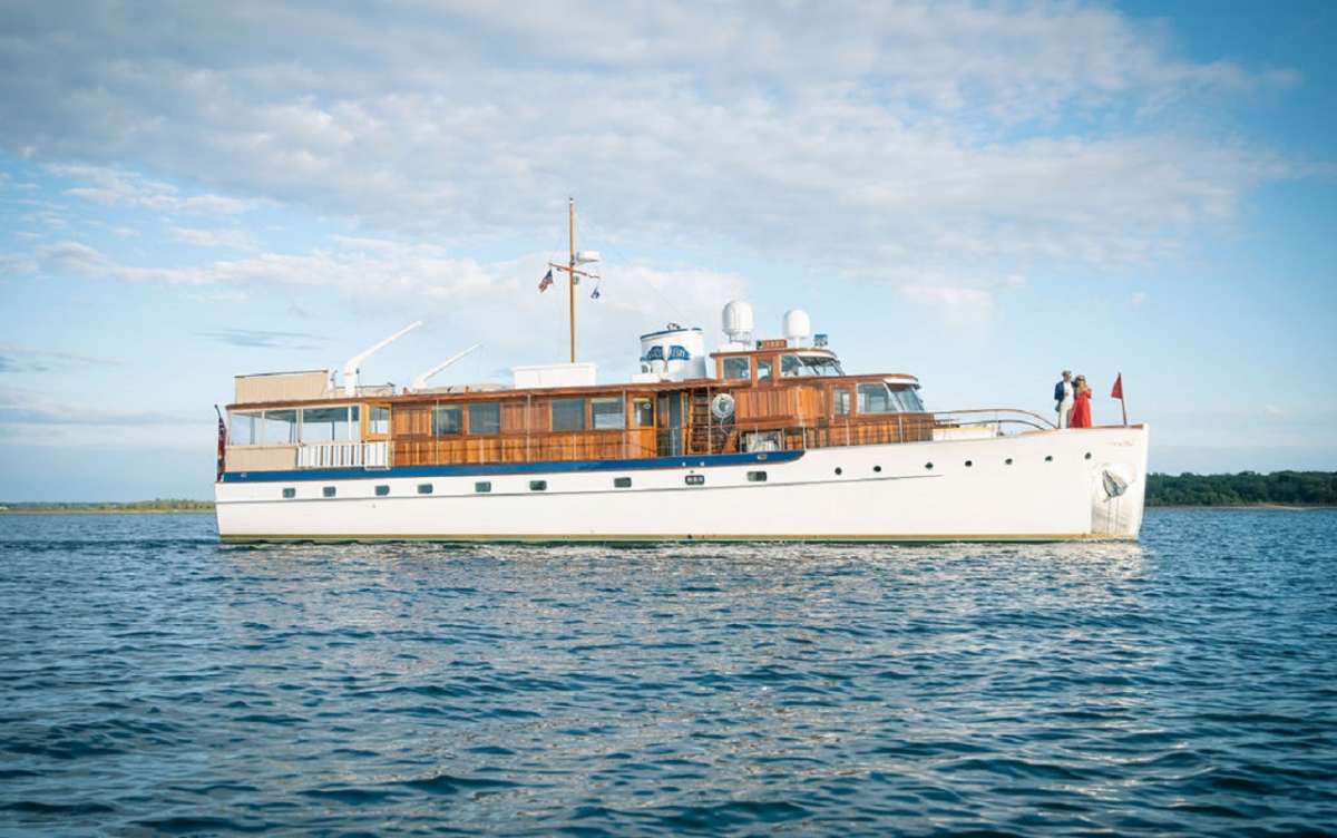 Having recently completed a 3+ year and $4 million + authentic restoration, the 80’ Trumpy motor yacht TIMELESS has returned to her original 1947 splendor. Understatedly called a “houseboat” by her designers because the yachts offered her owners all the comforts & amenities of home, Trumpy was considered the Rolls-Royce of American Yachting. Known for their meticulous craftsmanship owners of Trumpy yachts included the likes of Howard Hughes, the Guggenheims, Dupont’s, Chrysler& Dodge families. 

TIMELESS has generous walk-around decks and high stations with varnished teak cap rails. The aft deck has a large custom built varnished teak oval dining table which offers spacious seating for 8, with a curved banquette aft and 4 sturdy mid-century teak dining chairs.

The “card room” – which doubled as the original owner’s office, is located forward.  The card room offers great views while underway or at anchor and is a wonderful space with a cozy settee aft, and a forward ¾ day bed for sleeping an additional guest.  The opening windows have custom wood venetian blinds and port and starboard doors provide excellent natural cross ventilation for an alternative to the yacht’s new air conditioning system.  The foredeck is graced by a large centerline sliding teak hatch for deck access to crew quarters & galley.

Master Stateroom:  The beautifully appointed master stateroom is located aft and features a queen size centerline berth with original framed mirror above and flanked by matching dressers with generous drawers on either side. A large flat-screen television is hidden when not in use.  There are 2 large hanging lockers and a 3rd with deep shelves.  Period bedside reading lamps are located on either side of the mirrors with easily accessible controls.  Twin bench seats offer additional storage.  There is individual air conditioning control and the ports have restored original hand-crafted varnished teak shutters to darken the cabin for a restful night’s sleep.  The en suite bathroom features a teak and holly sole with a large washbasin, lighted storage, a large, tiled stall shower with seat and a Tecma fresh water flush head and traditional mirrored “medicine cabinet” that is original to the yacht.
VIP Guest Cabin: Exiting the master stateroom, the starboard VIP guest cabin has a walk-around queen bed and a large bathroom that can be accessed through the cabin or via the hallway. There are two large dressers, generous hanging lockers, period lighting, ports with sliding room-darkening varnished teak shutters and private climate controls.  The ensuite bath has a teak & holly sole, a large, tiled stall shower with teak grating, porcelain sink with mirrored original medicine cabinet, and Tecma fresh water flush head (toilet).

Guest Cabin 3: opposite the VIP cabin is the 3rd guest cabin that has been nick-named the “Nanny Cabin” -- as it has a lower double bed and upper single bed, a large hanging locker and generous dresser and the en suite bathroom is what is referred to as a “wet head” because it has an integral shower.  The teak-grated flooring speeds drying after a shower and there is a sink with original mirrored medicine cabinet. The Nanny Cabin has air conditioning controls and ports with sliding room-darkening varnished teak shutters.

Built in the era when a game of bridge was a favorite past-time there is a “card room” forward on the main deck that has a day bed which can sleep a 7th guest.  There is a day head in the salon with toilet & sink.  Crew quarters are forward of the galley & completely separate from the guest areas, with private crew head & shower.

