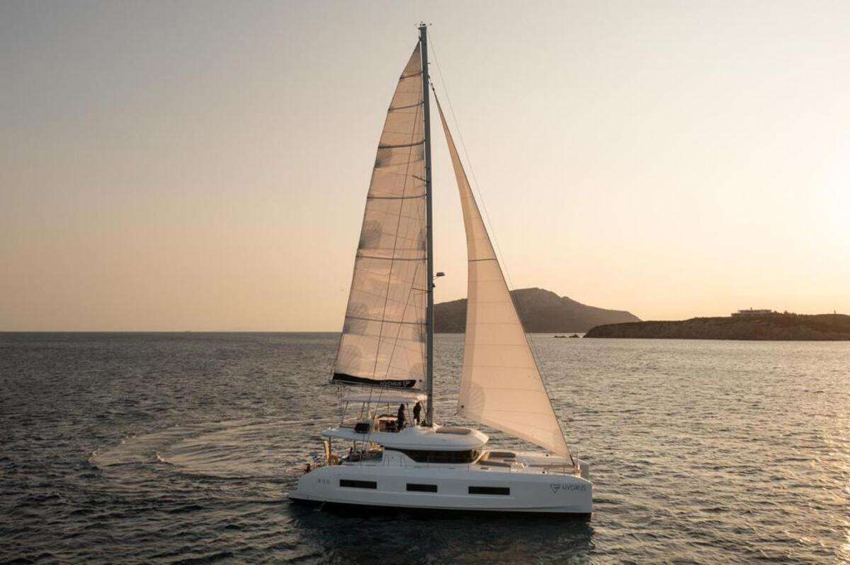 From Ancient Greek Mythology and myths in Astronomy to the numerical values of ‘5’ in Pythagorean Numerology and ‘3’ in Chaldean Numerology, it is no coincidence that this 2023 Lagoon 55 has been aptly named ‘Hydrus’ after the Greek Primordial God of Fresh Water.
The comforts of Lagoon 55 may be easily resembled to a much larger Lagoon with all the privileges and pleasures it has to offer. Hydrus has ‘5’ very spacious cabins consisting of 4 double en-suite cabins and 1 twin en-suite cabin which converts to a double if required. All cabins are airy and have a flow of indulgence, with mood lighting and a color palette that soothes yet stimulates your senses. This flow carries through to all other interior and exterior spaces. Hydrus’ features include upper and lower deck bar area and dining areas, upper and lower deck sunbathing and socializing areas, a fully decked galley with all contemporary amenities and a superbly serene as well as a spacious living room area.
Last but not least, the fierce S/Y Hydrus has a crew of ‘3’, ready and able to assist and support your needs and wishes while sailing towards your ultimate vacation experience. Gliding, floating, drifting… your quest to explore the Greek islands awaits you from the moment you step aboard this streamlined and efficient beauty.