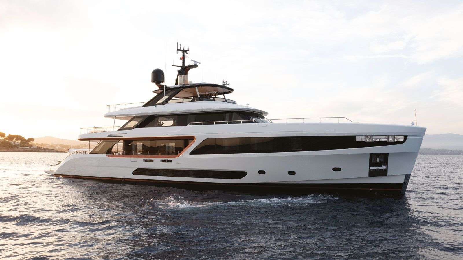 Delivered in 2023, ALLURIA’s contemporary interior, light-flooded rooms, and modern features are inspired by the glamorous Motopanfilo yachts built over 50 years ago. Accommodating 10 overnight guests in five cabins, she has a multitude of communal spaces and amenities to appeal to a mixed charter group or families alike.
One of her many highlights is the ’cocoon-style’ observation deck that provides an intimate space to enjoy a morning coffee or evening sundowner while taking in sweeping views. The spacious Hamptons-style beach club invites guests to relax in the sun at sea-level and features a retractable fabric canopy providing ample shade when needed; as well as a platform for easy access when enjoying one of the yacht’s broad selection of water toys. Her foredeck outdoor pool lounge is yet another exterior space to soak up the sun, with plush sun pads and a large swimming pool.
ALLURIA’s floor-to-ceiling windows, clever use of mirrors, and open-plan interior create an environment that is bright, sophisticated, and connected with the surrounding ocean. The main salon features wide-spanning windows, allowing guests to take in the incredible panoramic views even indoors, socializing on her comfortable sofa, sipping a cocktail by the cylindrical bar cabinet or enjoying a sunset dinner in her formal dining area. She provides seamless flow from the interior main salon to the main deck aft. Each of the cabins are well-appointed. The vast full-beam, on deck master suite is designed with natural light from the surrounding panoramic windows. It also features a private seating space that can be used as an office, a vanity and a generous en suite bathroom. Her four additional guest cabins are well-appointed and ideal for families, mixed groups and couples.