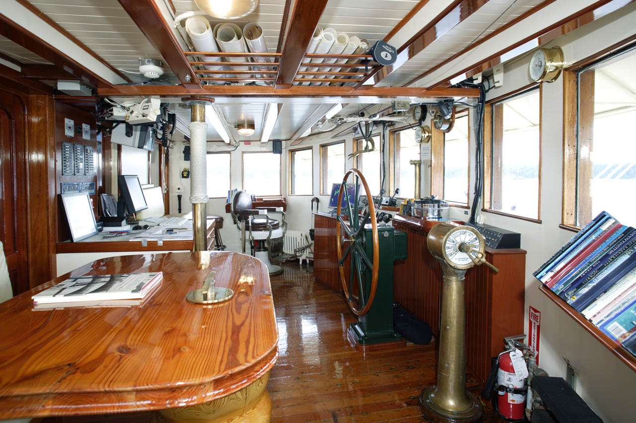 PACIFIC YELLOWFIN Yacht Charter - Wheelhouse with Forward View. Guest seating to the left at the table.