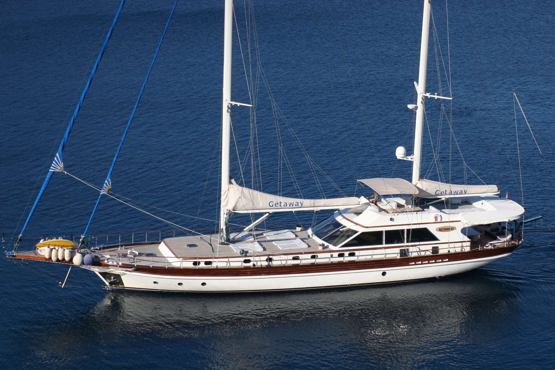 GETAWAY is one of the best sailing yachts available for charter in the Eastern Mediterranean and offers great value for money. She offers tremendous amount of exterior space as result of her wide beam, uncluttered forward deck and conveniently large flybridge. Size of the cabins equal those found on much larger yachts and consist of one very large master cabin with a California King size bed and three other double guests cabins. The flexibility to convert the two twin cabins into King bed configurations make this vessel an ideal option for four couples or families with children. Light colour interior, all around windows in the saloon and natural light from the skylight in the corridor provides a very modern airy atmosphere. Comfortable dining is possible in the aft deck, salon and flybridge. All cabins and the salon are equipped with TVs and entertainment systems but there is even a fold down TV in the aft section to allow guests to enjoy their favourite programs al-fresco. There are plenty of games and water sports available on board to be enjoyed throughout a charter. The yacht performs very well under sail, meaning her guests can not only enjoy her modern comforts but also the wonderful feeling of gliding through the turquoise waters of the Med.
