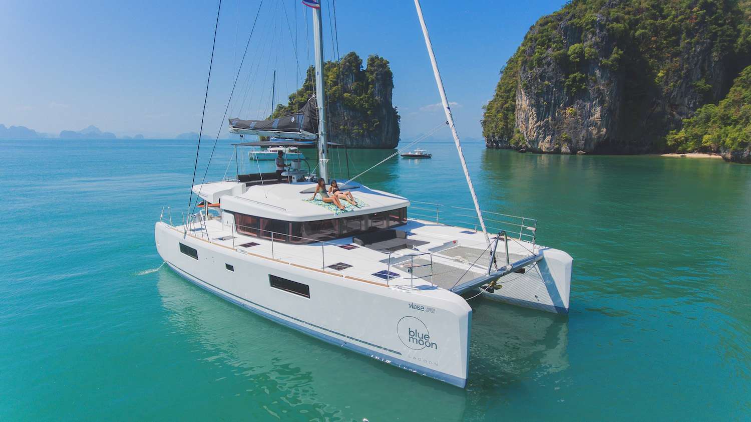 This brand new, fully loaded 2018 Lagoon 52F is now available for charter in Phuket (launched in mid. December 2017). Price includes two crew (skipper and hostess) and excludes food and fuel. Be among the first to charter this incredible yacht!
The Lagoon shipyard together with their yacht design partner VPLP who have used their experience of competitive sailing in developing a new style for a whole new generation of Lagoons, the Lagoon 52 is the first model introducing this new generation. With its diamond-shaped vertical bows, contemporary styled hulls and its levitated hardtop and with a taller rig moved aft the Lagoon 52 stands out from the crowd. But its originality goes a great deal further than just its “outer” appearance, or even its interior layout.
The saloon encompasses the lounge and dining table to starboard, a large galley to port which leads to direct access to the cockpit, together with the chart table in the middle, facing out to sea.
This Lagoon 52F in 2018 hull is in 5 cabin versions, including 4 queen cabins all with en-suite bathrooms and separate showers, and a bunk bed cabin with en-suite head. The cabins have incomparable natural lighting thanks to the fixed hull windows, together with excellent ventilation thanks to the deck hatches and portholes that open out to the hull-side or to the cockpit.
The mast is located further to aft, which brings many advantages on a cruising catamaran: a large forward triangle allows a larger sails choice: a promise for great performance. The shorter boom makes the mainsail much easier to maneuver. The mainsail, which is relatively narrower and higher, benefits from better winds at the top, thus enhancing performance by re-centering the weight in this way, pitching is considerably reduced.
The yacht is accessed via open aft transoms, facilitating boarding and disembarking. She has broad side decks, with recessed deck hatches. The cockpit is level with the saloon, and has an outdoor lounge and sun-lounging area to starboard. The fly bridge is reached either by a staircase leading from the cockpit, or by another leading from the deck on the starboard side. The steering station is positioned in the centre of the flybridge, giving the skipper perfect visibility. All ropes and controls are located on the flybridge, away from the living areas. A tilting steering wheel is also found which can be adjusted to three different positions, giving the skipper perfect visibility under sail or when maneuvering.
SY Blue Moon has been successfully launched and start providing high quality level charter services to her customers.