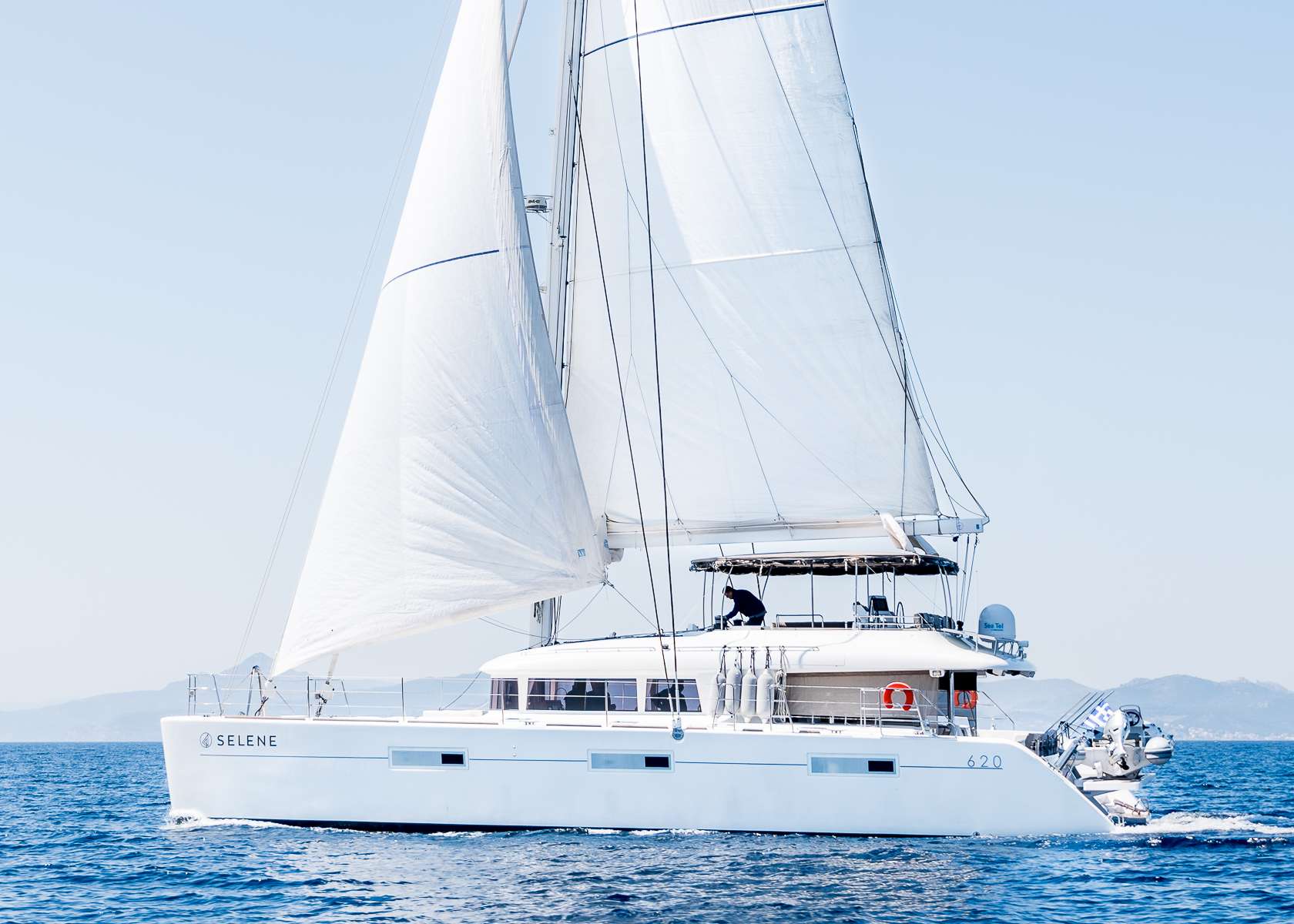 SELENE s a Lagoon 620 which first set sail in 2015. It is an innovative catamaran designed to suit the needs of yachtsmen looking for the ultimate yacht charter vacation experience.
The aft deck, protected from the weather by a hard top bimini, is really spacious with a dining table and relaxing space. One of the main highlights of ‘SELENE’ is the 17 sq. meter flybridge, ideal for relaxing & sunbathing. The tender is located on a hydraulic platform which transforms into a private swimming deck.
SELENE is available for charter in the Mediterranean, cruising the very popular Greek Islands. This new yacht and experienced charter crew are ready to guide guests on the ultimate yachting getaway through some of the most beautiful landscapes on earth.
Selene accommodates 10 guests in 5 queen bed cabins all with private bathrooms.