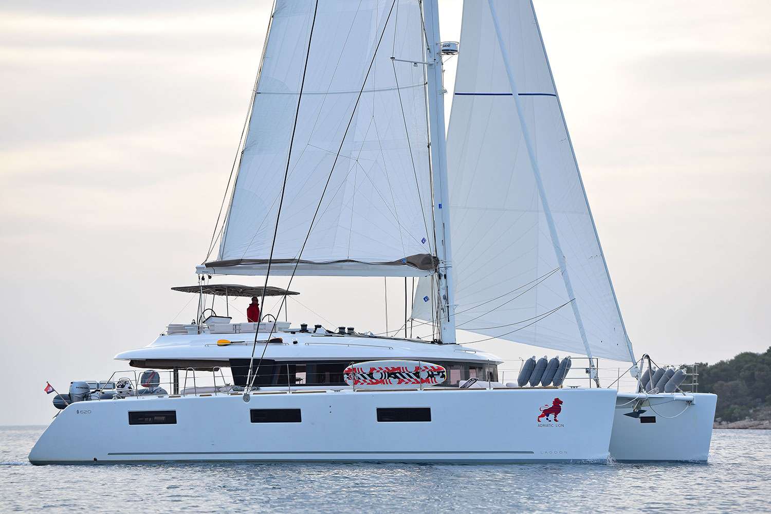 If you want a well built, high performance catamaran, then the Lagoon 620 is one of the best on the market today. Whether you are vacationing with your family, or entertaining guest, this is a catamaran that is hard to beat.
Lagoon 620 Adriatic Lion is ideal for the clients who wants to experience the art of living aboard in an innovative way.
There is just nothing to compare to relaxing aboard this charming & luxurious catamaran. Lagoon 620 Adriatic Lion with five queen size en-suite cabins design is very accommodating. Complete interior layout is elegantly incorporating wood finish, upholstery, inner liners, and more. A functional fly bridge can also accommodate guests thanks to separate crew and reception areas. Saloon and cockpit are beautifully integrated and include “wet bar”, areas for lazing around and the option on taking delicious meals inside or out without having to make any adjustments.
