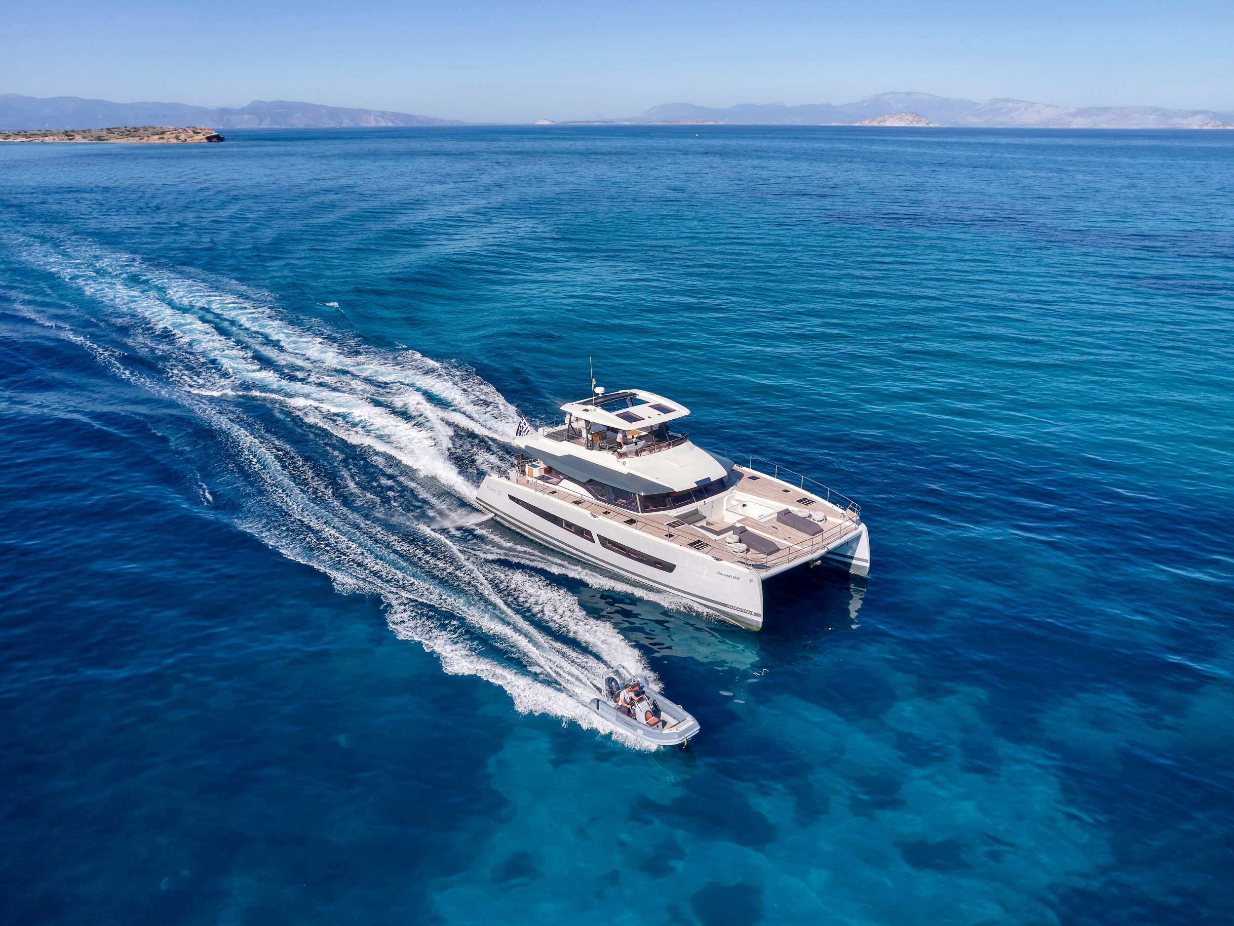 ChristAl MiO combines all the strengths of a power catamaran with Fountaine Pajot’s extensive experience producing award-winning motor yacht and luxury catamarans. The Power 67 is the Flagship model of Fountaine Pajot’s Motor Yacht range and boasts all the signature features of the shipyard’s highly acclaimed lineup, yet has also inherited the luxury, space and elegance of the stunning Alegria 67 sailing catamaran.
Space and Exquisite Comfort.
ChristAl MiO is synonymous with uncompromising luxury where space and comfort equate with elegance and dynamic vision she has a distinctive slender thoroughbred lines and a contemporary, more rounded asymmetric interior style in keeping with the latest trends. The yacht has been designed with expansive entertaining and relaxation spaces inside and out while assuring uncompromising standards of safety and performance.
Her 36m² cockpit is designed for unforgettable social occasions, opening fully onto the lounge with several sunbathing spots, a galley with a plancha grill and a dining setting to cater for a large number of guests.
Her vast 32m² Flybridge, foredeck with Jacuzzi, and Owner suite are simply remarkable and all enjoy direct access from the saloon.
The Luxury of a Five-Star Hotel, privacy and conviviality.
In the Owner’s cabin suite is a dedicated 22m² private apartment featuring a capacious dressing room with sofa. An exclusive door to the front Cockpit provides convenient exterior access while retaining privacy, and the Owner’s bathroom epitomizes luxury at sea with a spectacular walk-in shower and designer twin vanities.
