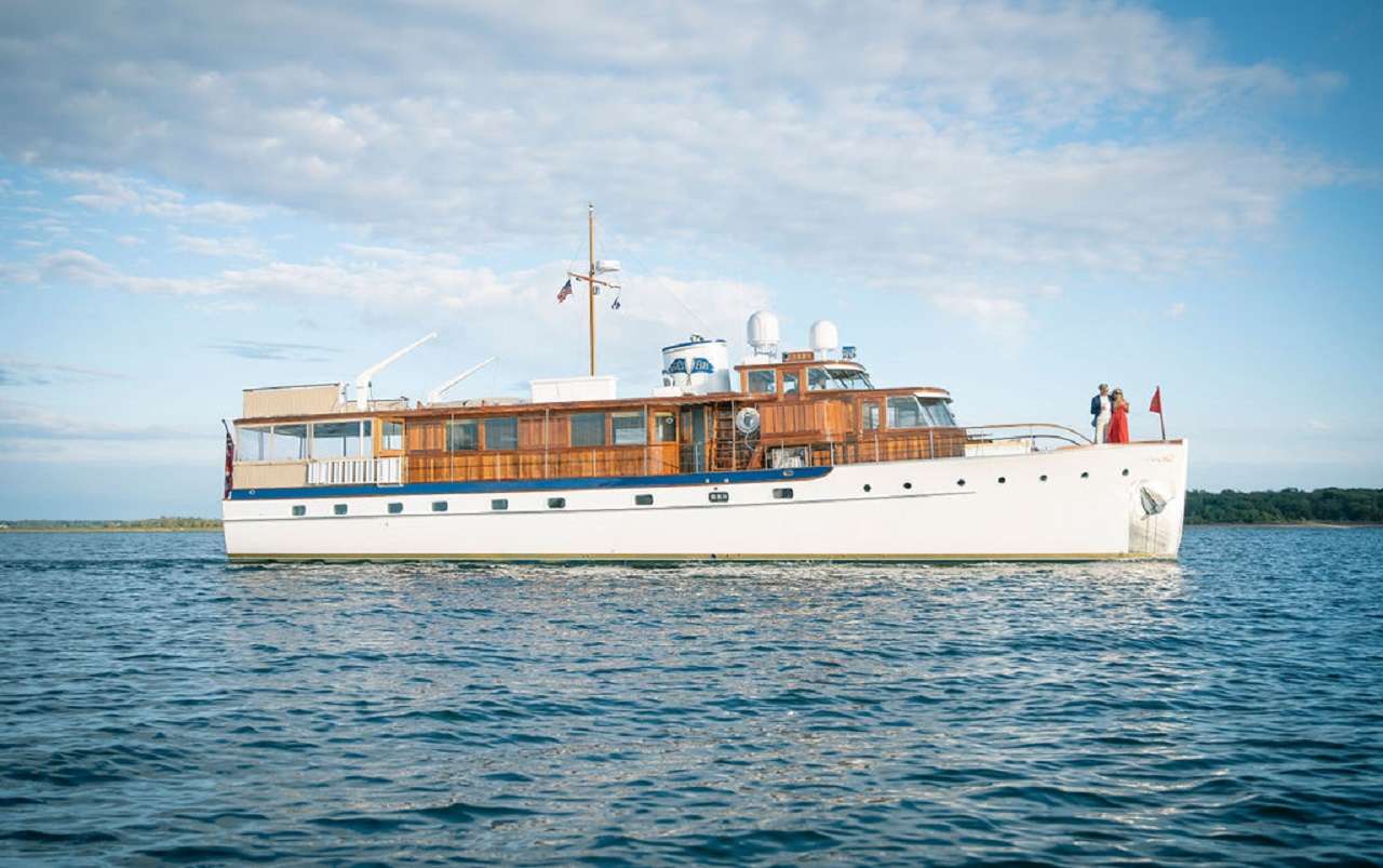 Having recently completed a 3+ year and $4 million + authentic restoration, the 80&rsquo; Trumpy motor yacht BB has returned to her original 1947 splendor. Understatedly called a &ldquo;houseboat&rdquo; by her designers because the yachts offered her owners all the comforts &amp; amenities of home, Trumpy was considered the Rolls-Royce of American Yachting. Known for their meticulous craftsmanship owners of Trumpy yachts included the likes of Howard Hughes, the Guggenheims, Dupont&rsquo;s, Chrysler&amp; Dodge families. 

BB has generous walk-around decks and high stations with varnished teak cap rails. The aft deck has a large custom built varnished teak oval dining table which offers spacious seating for 8, with a curved banquette aft and 4 sturdy mid-century teak dining chairs.

The &ldquo;card room&rdquo; &ndash; which doubled as the original owner&rsquo;s office, is located forward.  The card room offers great views while underway or at anchor and is a wonderful space with a cozy settee aft, and a forward &frac34; day bed for sleeping an additional guest.  The opening windows have custom wood venetian blinds and port and starboard doors provide excellent natural cross ventilation for an alternative to the yacht&rsquo;s new air conditioning system.  The foredeck is graced by a large centerline sliding teak hatch for deck access to crew quarters &amp; galley.

Cabin configuration:
Master - The generously appointed master stateroom is located aft and features a queen size centerline berth accompanied by a built-in pop up flat-screen TV that goes up and down as desired by the guest. Twin aft bulkhead dressers and bedside reading lamps are located on either side of the queen berth. The bulkhead mirror lies above the queen berth. Twin bench seats and hanging lockers are located on either side of the queen berth. En suite facilities located port feature teak and holly sole with a large washbasin, mirrored vanity, 2 storage lockers, Tecma fresh water flush head, &frac34; bathtub and shower. 2 sliding shuttered opening ports allow fresh air to flow freely.  

Guest 1: Exiting the master stateroom, the starboard twin guest cabin en suite facility is located to starboard and forward is the starboard twin guest cabin. The guest cabin features a twin berth with the option to convert to a full-size queen berth. Desk and bureau accompany the berth as well as a hanging locker. Entering the en suite facilities, stall shower with teak grating, generous storage, Tecma fresh water flush head and mirrored vanity. 

Guest 2: Exiting the twin stateroom and moving forward to port, a third cabin features upper and lower bunks with a shared day head.

