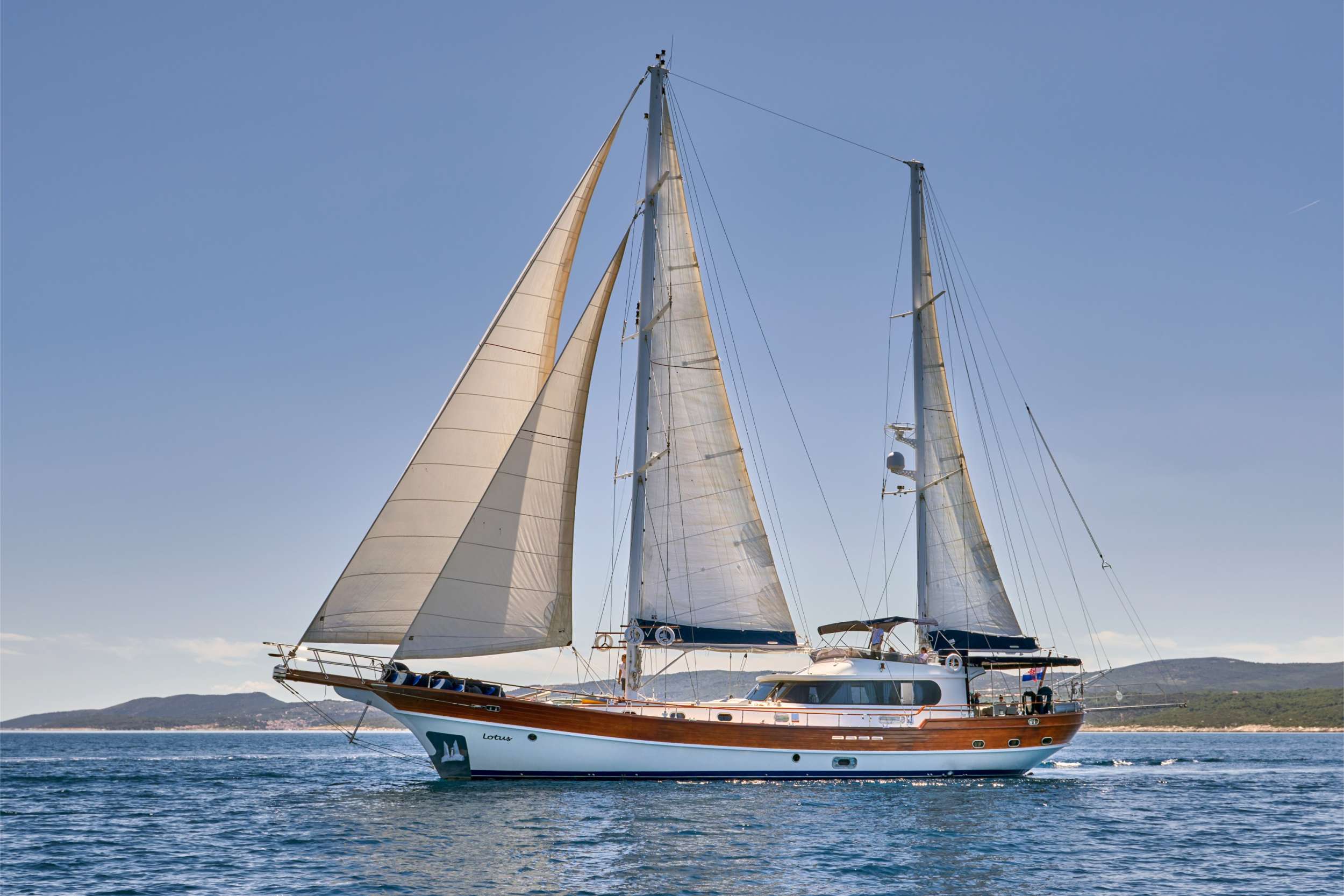 Gulet Lotus was built in 2006 by Huzur Yat - one of the finest Turkish shipyards when it comes to luxury yachts building. This boutique gulet was built for a private owner, a passionate wealthy sailor who decided to sell it in 2018, as he couldn’t find enough time in his busy schedule to enjoy on his beloved yacht. During 12 years of his ownership, the main engine of the yacht had less than 300 working hours.
In August 2018, the yacht was purchased by the Croatian owner to be introduced as a new entry to the luxury yacht charter market in Croatia for the season 2019.
Gulet Lotus comprises a stylish interior, two (out of total 4) impressive cabins, sleek exterior lines, and serious sailing equipment which ensures proper sailing experience onboard.
Let us walk you through the interior of the yacht first: entering from the aft you are stepping into the spacious salon, designed to be a perfect relaxation zone – your living room at the sea. On your left is the lounge area with a coffee table, opposite to it is TV; in front of the lounge area is inside the steering place while in the right front corner is the inside table. All fabrics are of high quality, interior wood is cherry, and large panoramic windows around the salon are ensuring plenty of natural light and an airy atmosphere.
The moment you step on board this magnificent yacht, relaxation and chilling seem as inevitable, if not the only possible attitude to the world around you.
Down the stairs from the salon, to the aft – in its separate area Master cabin is placed. Island bed in the middle of the cabin which takes side-to-side width. Sofa on one side, working-or-vanity table on the other side, walk-in closet, TV and minibar, all dressed in rich cherry wood clearly shows that the interior was inspired with the Ottoman style, providing that special sophisticated atmosphere that radiates with elegant serenity and take-your-time philosophy.
Stepping down the stairs from the salon to the front area of the yacht you will visit 3 other cabins: one double bed, one twin bed – one opposite to another, and in the very front: a VIP cabin; also stretching from side to side, with plenty of wardrobe space, TV and minibar.
Ok, so we’ve finished the interior walk, let’s go up to the deck and start the exterior tour from the aft: here Lotus offers an area for relaxation and al-fresco dining; aft mattresses, spacious dining table with chairs around it, all covered (shaded) by tent construction.
The front deck is definitely an area for the sun lovers during the day - as we mentioned, Lotus will provide an excellent sailing experience, therefore this area is not covered with a tent or awning as sun protection. Still, at the sunset time, this is probably the best area to spend this time of the day as Zen moments are assured to everyone comfortably lying on those mattresses.
Upper deck or sun deck or flybridge; you are invited to join the captain while he is steering from this position – there is a cocktail table and shaded lounge area for you. Or perhaps you want to enjoy it in privacy – so the captain will move to steering place in the salon.
Luxury gulet Lotus offers to her guests a wide range of entertainment as she is well supplied with water sports equipment.