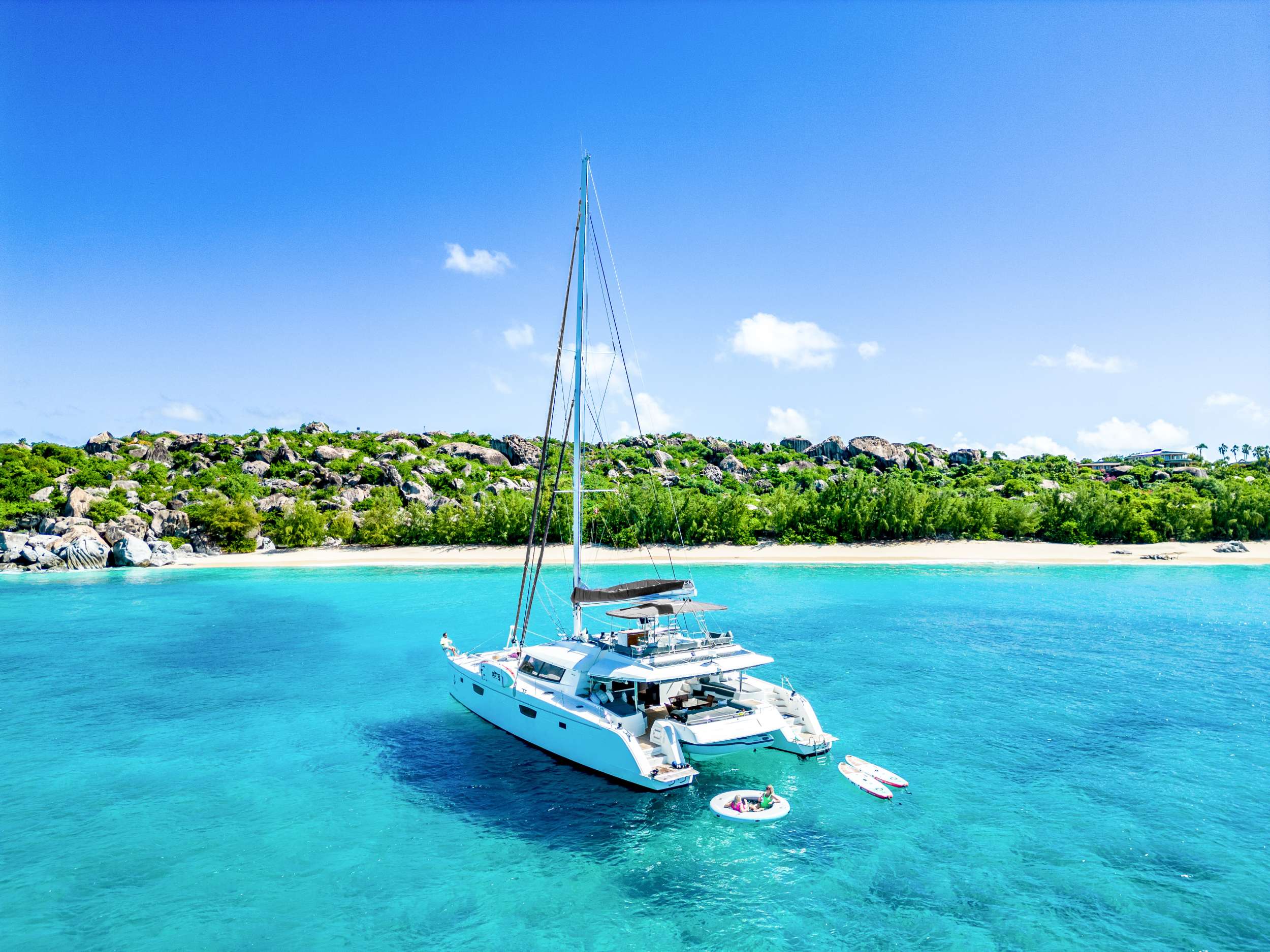 True Story is a Fountaine Pajot Victoria 67. Built and launched in 2017. She is an excellent addition to Fountaine Pajot’s top-of-the-line luxury cruising cats and is considered the Flagship Class of Fountaine Pajot's offerings. She’s sleek, elegant, and extremely spacious with an overall length of 67 feet and a beam of 31 feet. She is truly the ultimate in cruising comfort.
The magnificent flybridge with bimini represents the intersection of comfort and design and can be accessed from the cockpit by staircases on both sides. For guests who have come to relax, the seating area offers the luxurious comfort they seek, featuring benches, side tables, a relaxing sofa, and the convenience of a wet bar. The sizable bimini provides a large area of escape from the sun for those who want some shade, and there is integrated lighting for evening cocktails. This can all be enjoyed as amazing views of the surrounding scenery slowly drift by.
The large aft deck is shaded by the flybridge overhead, and provides additional comfortable lounging spaces, as well as an elegant setting for formal dining. Two large, sumptuous pads in addition to a full aft sunbed, accent the ambiance, and are ideal spaces for relaxation at any time of day.
A step through the glass doors into the salon reveals a spacious and comfortable area to entertain, or just relax in air-conditioned comfort if so desired. The open galley is equipped with state-of-the-art appliances and kitchenware and the crew is always on hand to provide top quality service.
You couldn’t make a better choice as she comes with a complete assortment of top-of-the-line water toys and entertainment options that will keep the entire family satisfied.
True Story hosts up to 8 guests - 2 Kings - 1 primary suite and other king can be converted to 2 twin beds, 2 queens, air-conditioned cabins. Each cabin has its own, private ensuite bathroom with a separate shower. The primary suite is elegant and roomy and includes seating/lounge area, a desk, and king size berth and the ensuite bathroom has a separate large glass shower stall and double vanity.