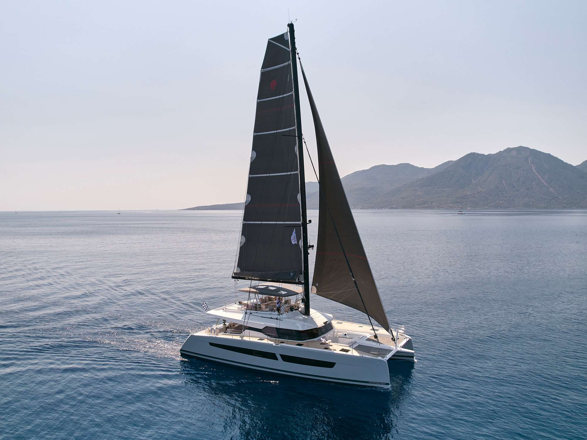 S/Y ALEXANDRA II is a newly built Alegria 67 built by Fountaine Pajot and offers all the comfort plus performance.
Her massive fly bridge with two large sunbathing beds at the aft. The fly bridge offers a 360 degree view and makes and perfect atmosphere for cocktail time.
Main deck offers two different seating areas. The fore deck is with a nice seating area next to the Jacuzzi. In the aft deck is where all the action happens, A large dining table for 8 persons with ample space. She sports a hydraulic bathing platform which is idea for watersports, sun bathing and even great place for yoga.
Moving indoors a full size saloon area to relax place cards or watch a movie. The kitchen is located in the lower deck.
Alexandra II accommodates 8 guests in one master cabin with desk area, full size bathroom (double sink) and two access points (one from inside the yacht and one from the foredeck jacuzzi area).
One queen guest cabin with private bathroom and TV. Two queen bed guest cabins with private bathroom and accessed from aft deck area with TV.