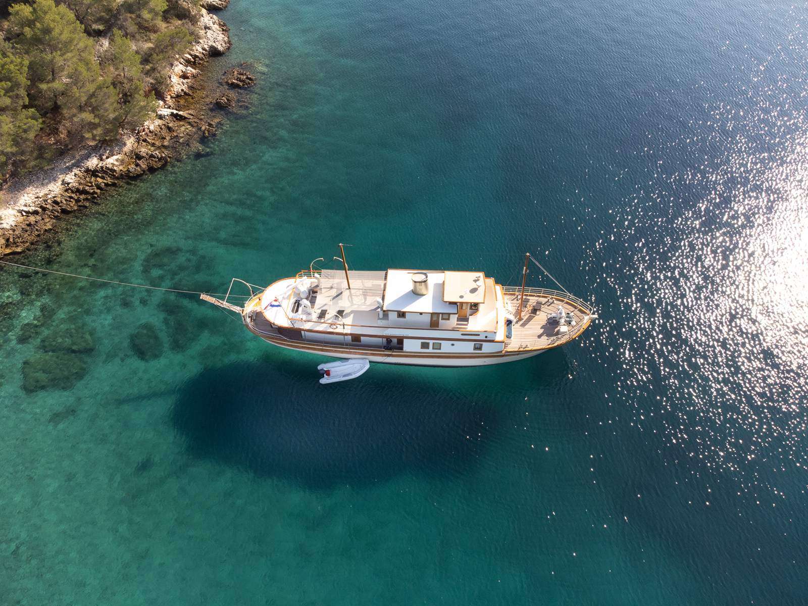 A new addition to our fleet, classic motor yacht Gallant tells a great story of tradition and a lifelong connection with the sea.
Ivan Antišić, enthusiast and owner of the yacht Gallant, has carried out a unique project starting from an idea that he had developed over the years. Combining tradition and wooden shipbuilding with the requirements of the luxury market, he created a unique product that combines tradition with modern trends in interior and yacht industry.
Motor boat Gallant is today completely renovated and luxuriously equipped to accommodate 10 passengers in 5 spacious cabins with a main goal to provide clients high class living on the sea. With many years of experience in the luxury yachting industry, the owner will make sure to provide you with top service.
For accommodation and service to the gastronomy, the crew on Gallant is trained to give you high level experience and introduce you with all the beauties of Adriatic. flows into a spacious salon, which combines modern industrial decoration with carefully chosen classic details. Many details are handmade which gives them a special charm. Cabins and toilets are really spacious, all air conditioned, with plenty of space for luggage and personal belongings.
On the sun deck there is a lot of space for you to relax and sunbathe and also a gym with multiple gym equipment (spinning bike, stepper, dumbbells, mat and more). Individual private training can also be organized.
This “gentlemans yacht” is designed according to all safety standards for passenger ships in the ship register class and provides you calm and relaxing sailing. During the refit in 2020 special attention was given to making the cabins super silent with thick sound proof walls, enabling complete privacy and comfort. Therefore, there are all the prerequisites to spend a perfect vacation on board. You just need to come and enjoy it!