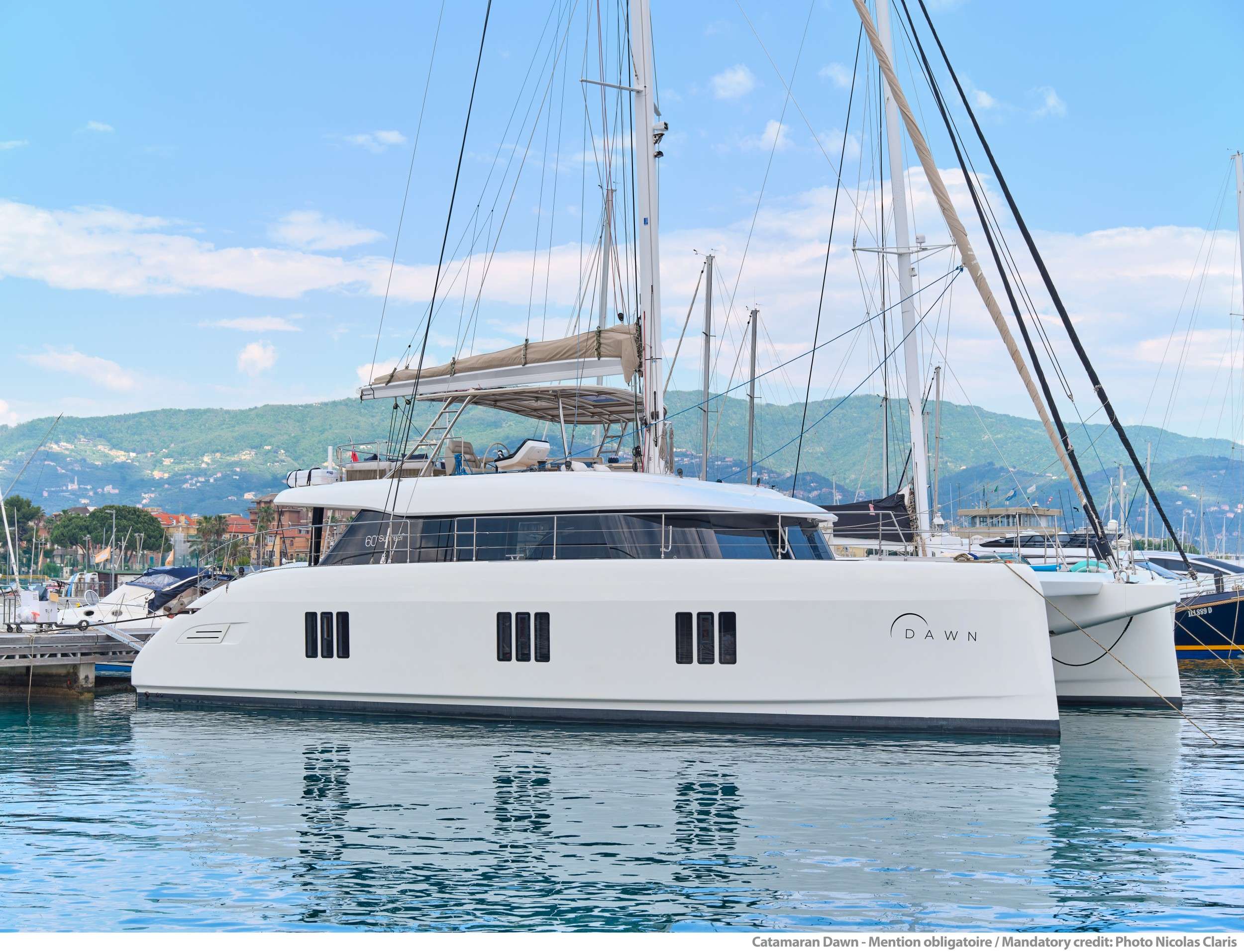 A 2019 launch and 2023 refit by AE interior, Sunreef 60 DAWN features both, a smart and charter-friendly layout as well as impressive and relaxing social areas at the bow, stern cockpit and flybridge.
DAWN’s light-filled interiors provide a relaxing and harmonious feel by its neutral and calming, yet stylish decor. Up to 8 guests can enjoy sophisticated accommodation in the yacht’s three classy ensuite cabins plus the stylish master suite. The bright main saloon, generous stern cockpit and ample front terrace merge into one luminous semi-open lounge area with a functional galley, cozy settees, a widescreen LED TV and a big table for 8 guests. While the well-equipped galley provides for fine cuisine, the indoor herb garden ensures a steady supply of freshness to DAWN’s rich menu.
Up on the catamaran’s impressive flybridge, guests can gather for lounging and drinks on the welcoming and pampering sofas. Versatility of this area allows it to also serve as a perfect space for yoga or light exercising, all while enjoying the spectacular sea view.
A lucky find for water sports enthusiasts, DAWN boasts a great selection of all new water toys, including towables, diving scooters, drone submarine for underwater exploration, wakeboard, water skis and stand-up paddle boards.
This dream yacht is operated by a dedicated and experienced crew of professionals ensuring top service and a memorable summer charter experience in the Amalfi Coast and Sardinia (contact us for the detailed schedule).